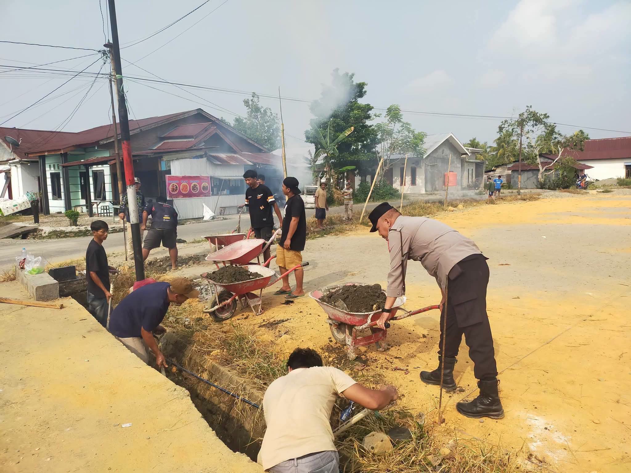 Bhabinkamtibmas Polsek Bone-Bone Bersama Warga dan Mahasiswa KKN Unanda Palopo Semangati Gotong Royong di Desa Patoloan
